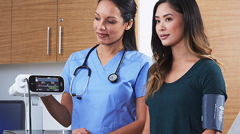 Nurse taking measurements from a patient in a physician office using a Masimo Rad-97 pulse oximeter. 